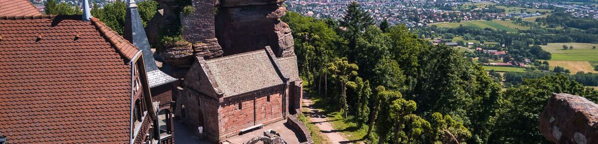 Plunging view of the chapel and the sandstone rocks of Haut-Barr Castle, with the Alsace plain in the background