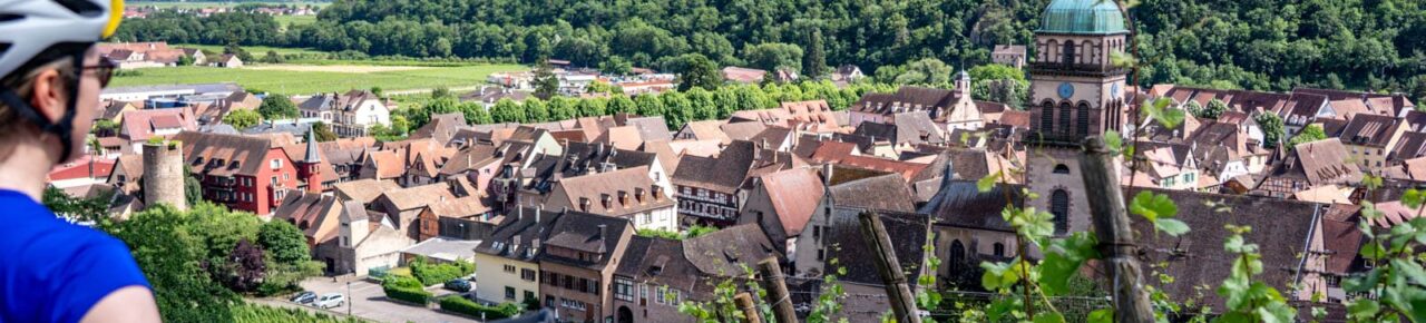 Cyclist looking out over the village of Kaysersberg in Alsace