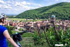 Cyclist looking out over the village of Kaysersberg in Alsace